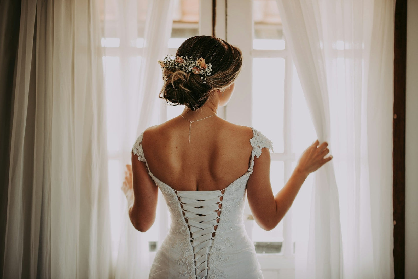  A bride wearing a wedding dress looking out a window