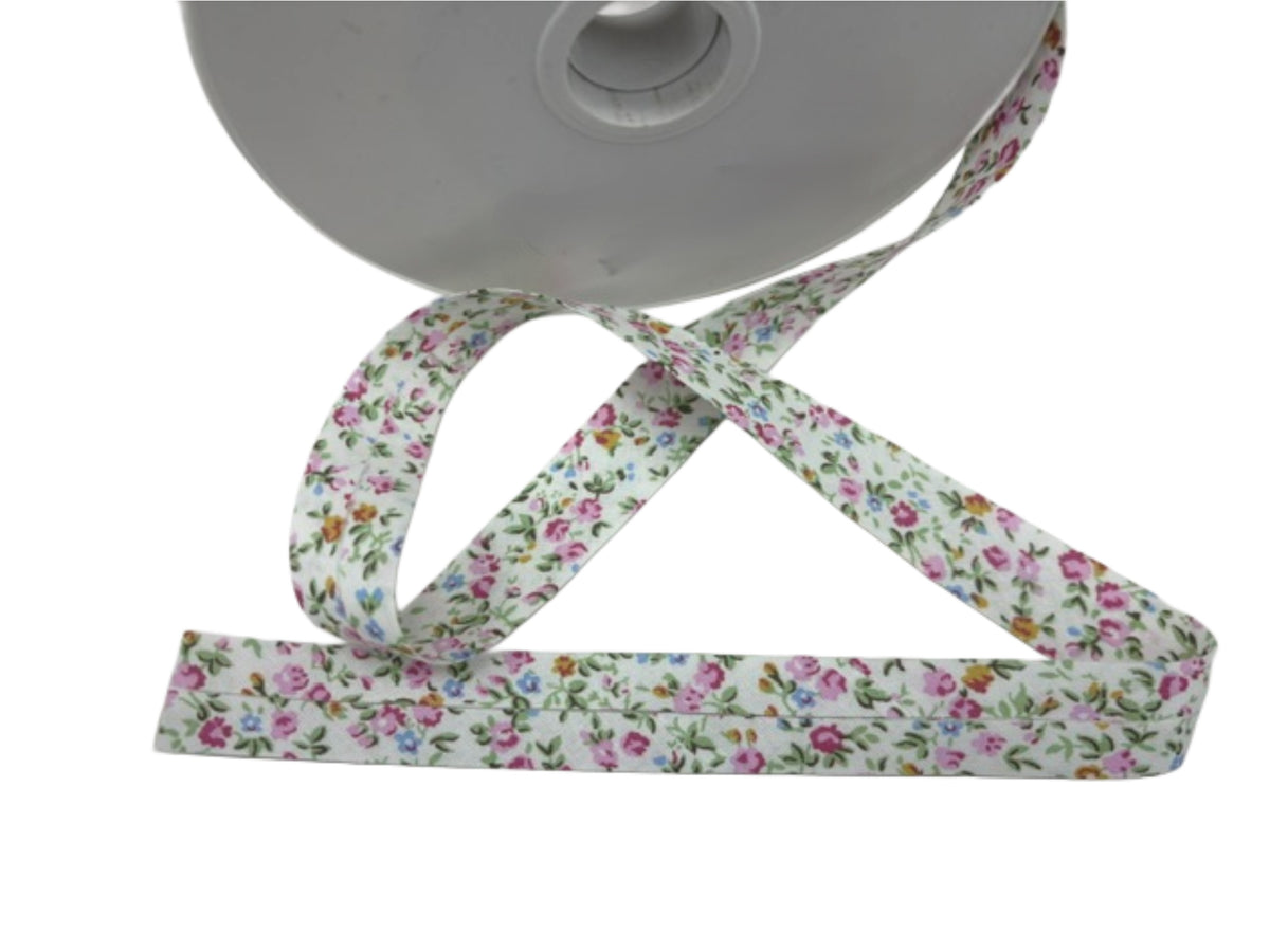 Pink and white floral Bias Binding Cotton Tape by Stephanoise, showing the soft, flexible fabric with a floral pattern.