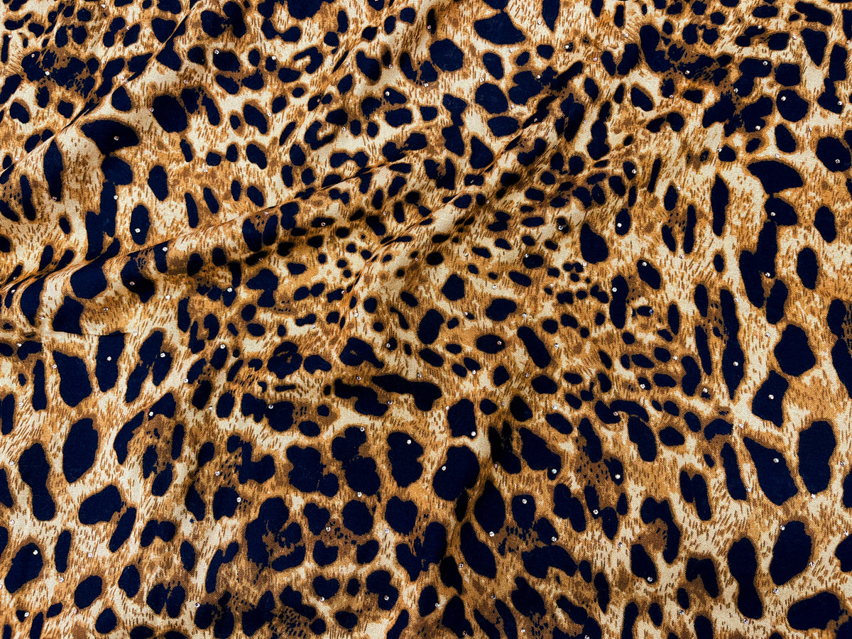 Animal Magic Dew Drop printed viscose fabric in amber with a vibrant animal pattern, showcasing soft, flowing material texture.