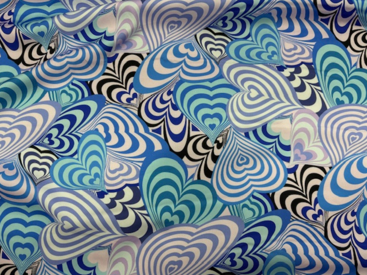 Blue satin fabric featuring bold retro hearts pattern from Cheap Fabrics, showcasing a smooth, luxurious soft satin texture.