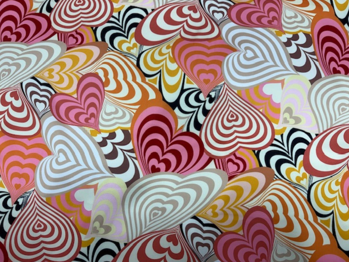 Coral Bold Retro Hearts Luxe Super Soft Satin fabric by Cheap Fabrics, showing a vibrant heart pattern on smooth satin material.