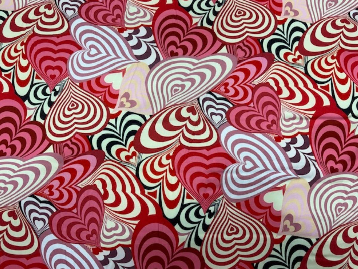 Red satin fabric with bold retro heart patterns from Cheap Fabrics, showcasing smooth, luxurious super soft satin material.