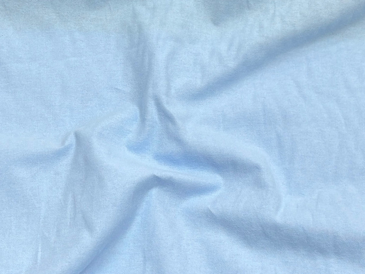 Baby blue Wynciette fabric made from brushed cotton, showcasing its soft texture and smooth weave, ideal for cozy sewing projects.