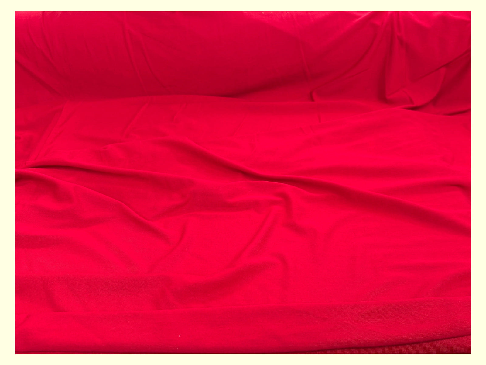 Red cotton mix jersey fabric from Cheap Fabrics, showcasing a smooth texture and vibrant color ideal for various sewing projects.