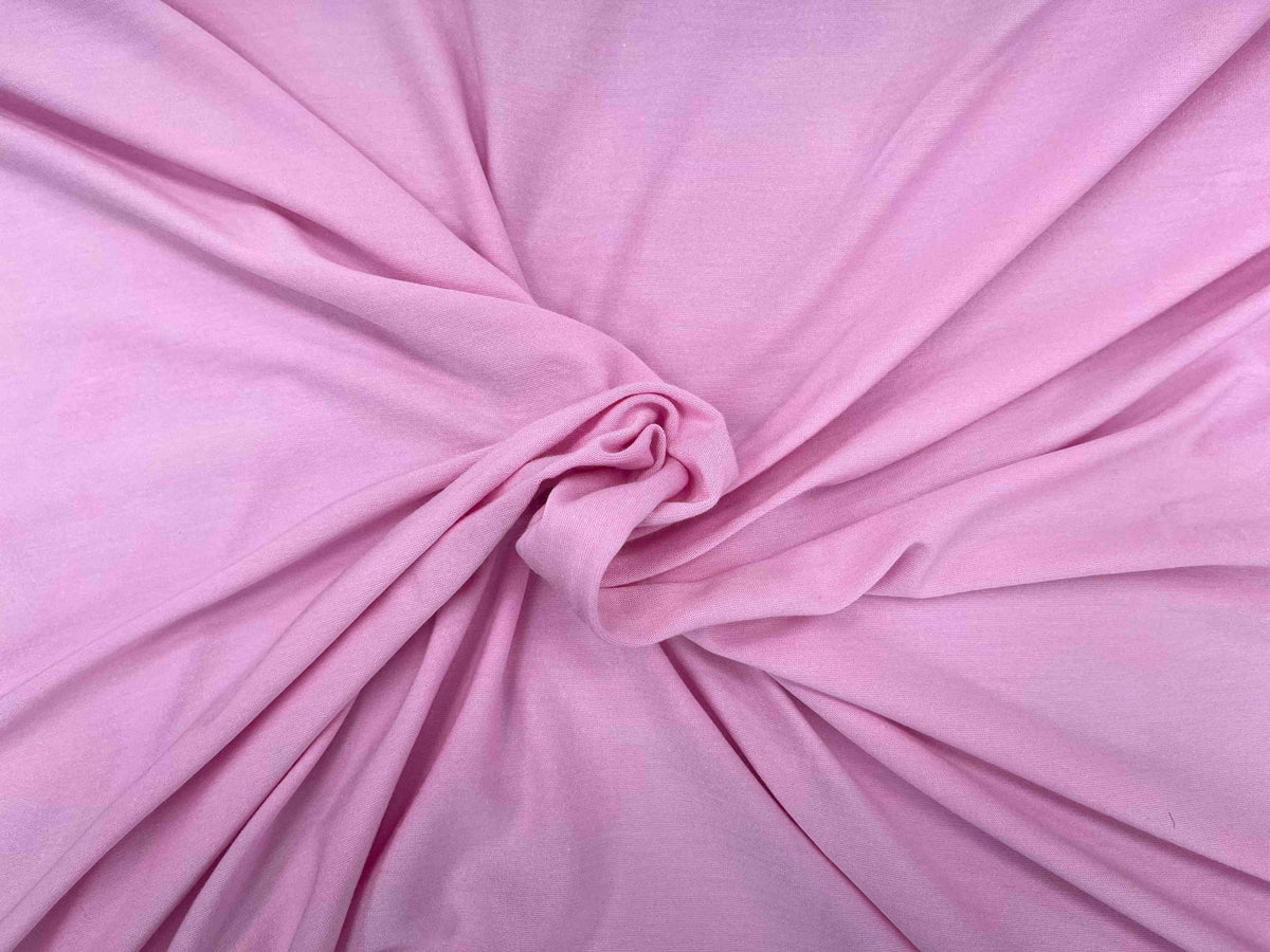 Pink cotton mix jersey fabric with a plain, smooth texture, ideal for clothing and sewing projects.