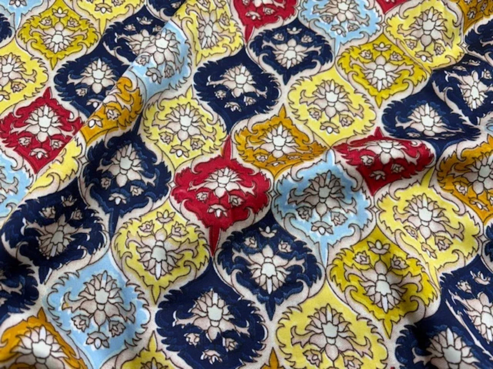Lemon-colored Crest printed crepe satin fabric by Cheap Fabrics, showcasing smooth, shiny crepe texture and vibrant print.
