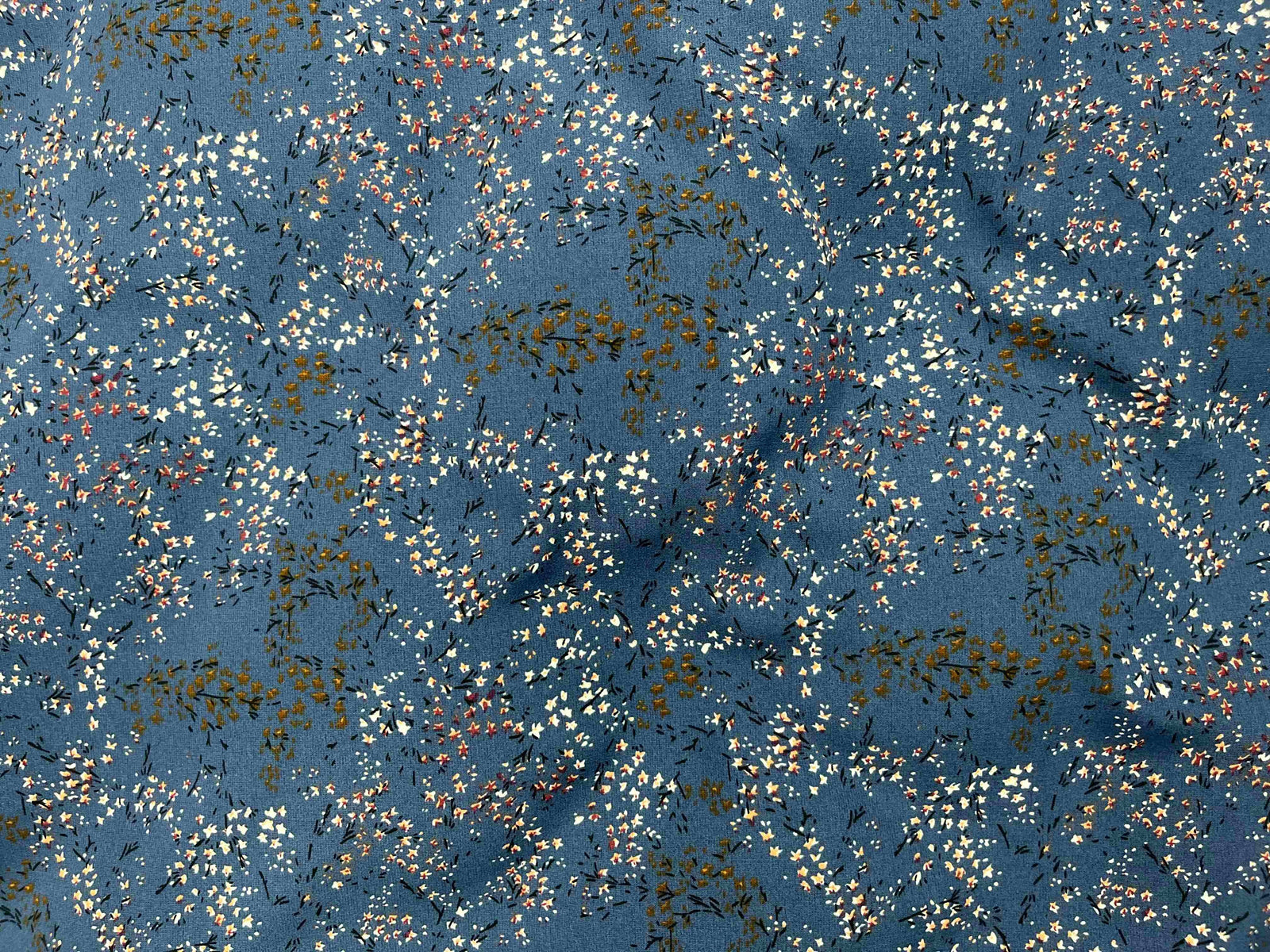 Blue denim crepe fabric with a ditsy printed pattern, featuring a blouse and denim shorts from Cheap Fabrics.