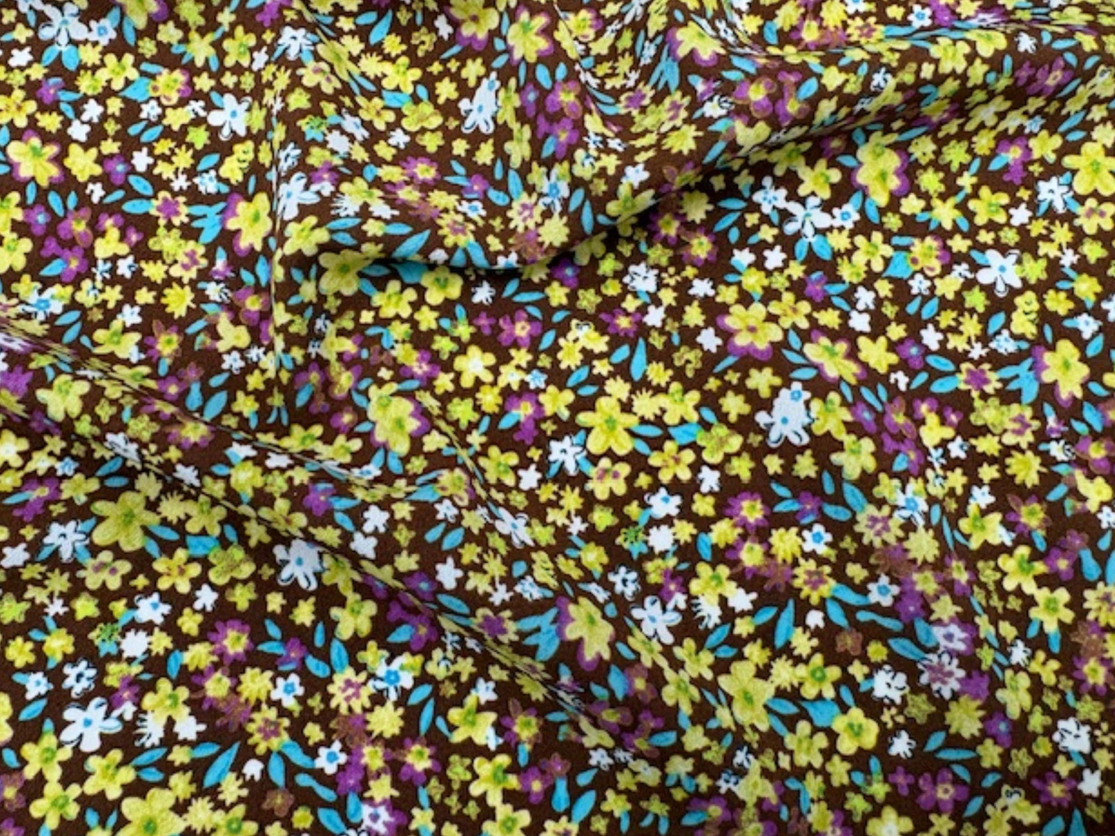 Brown and lime ditsy floral printed crepe fabric from Cheap Fabrics showing a close-up of the patterned textile.