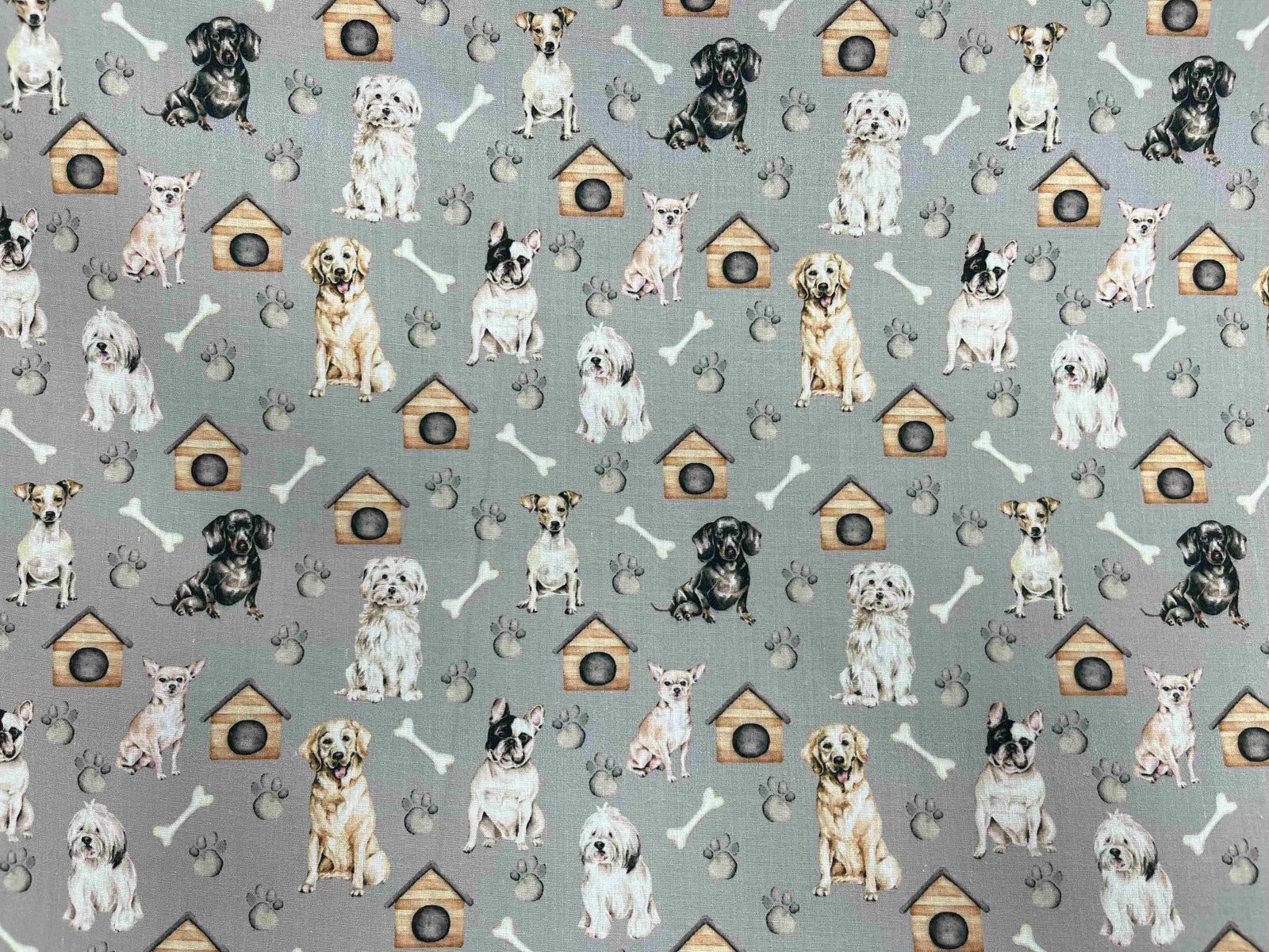 Grey polycotton printed fabric featuring playful dog and bone patterns, ideal for sewing projects and crafts.