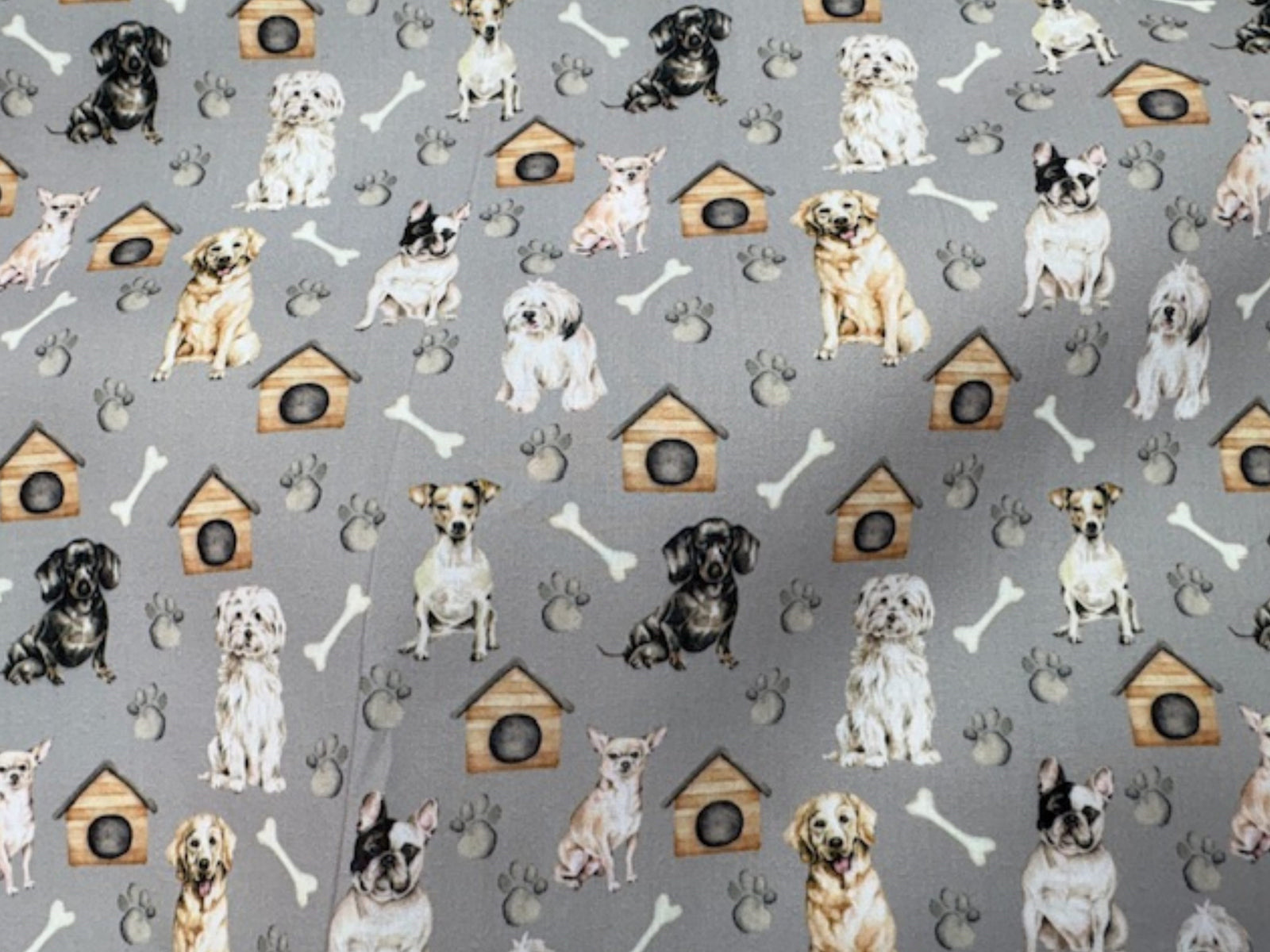 Grey polycotton printed fabric featuring playful dog and bone patterns, ideal for sewing projects and crafts.