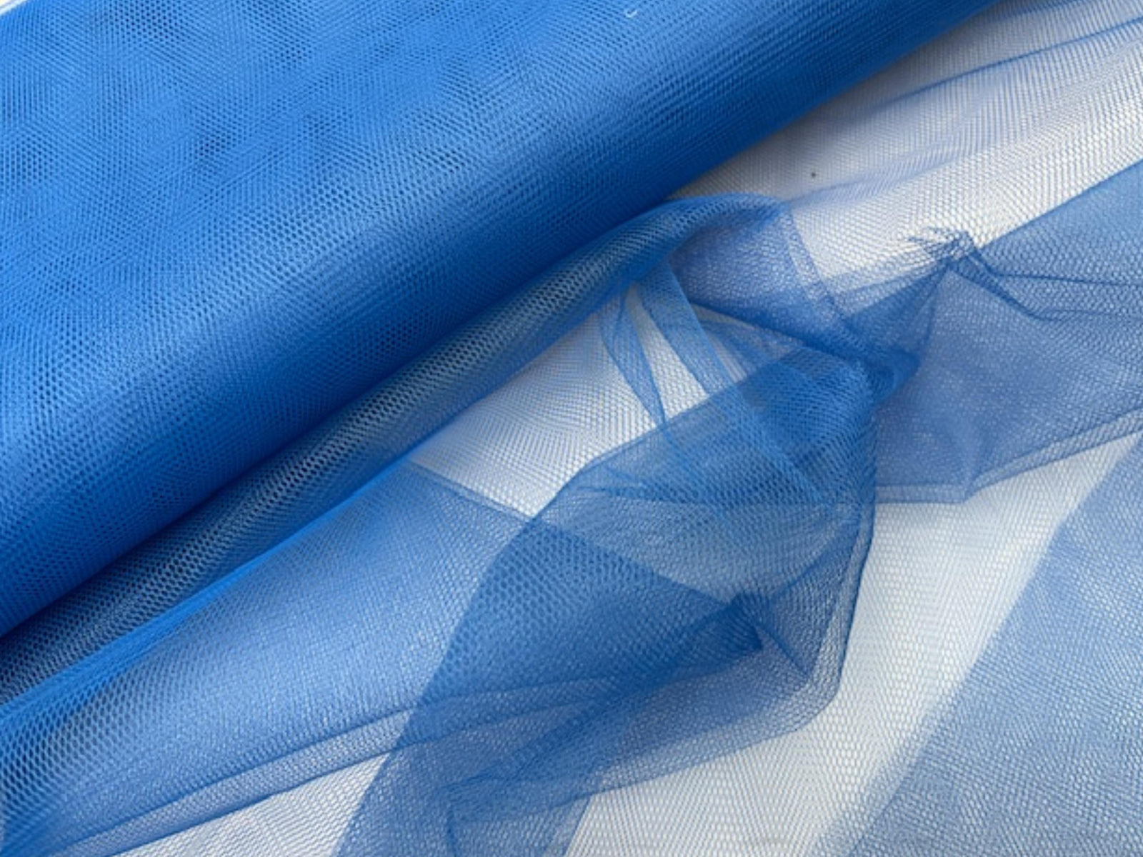 Mid-blue dress net fabric from Cheap Fabrics, showcasing lightweight, fine netting suitable for dresses and fashion projects.