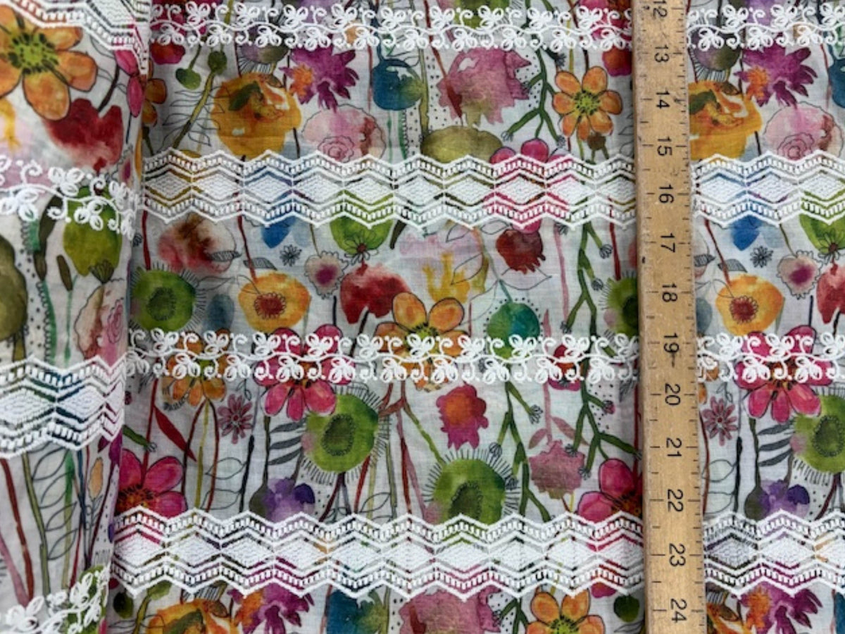 Embroidered cotton lawn fabric with multi-floral stripes in white, ideal for dresses, by Cheap Fabrics.