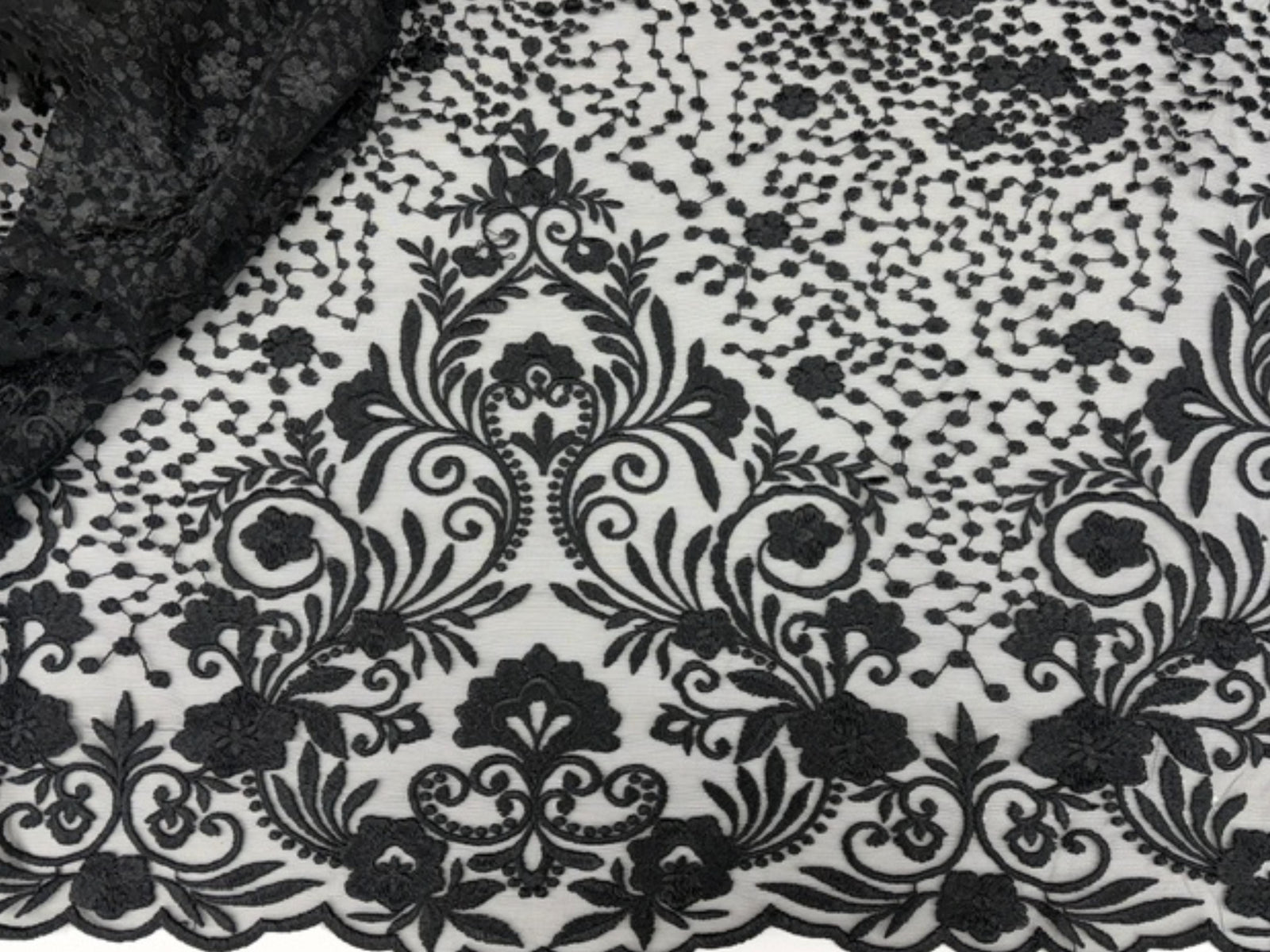 Black embroidered tulle fabric from Cheap Fabrics' Design 10 collection, featuring delicate embroidery on lightweight tulle material.