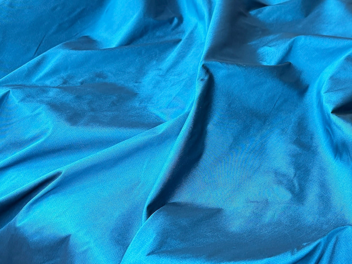 Peacock-colored faux silk taffeta fabric by Cheap Fabrics, showcasing smooth, shiny, and luxurious textured taffeta material.