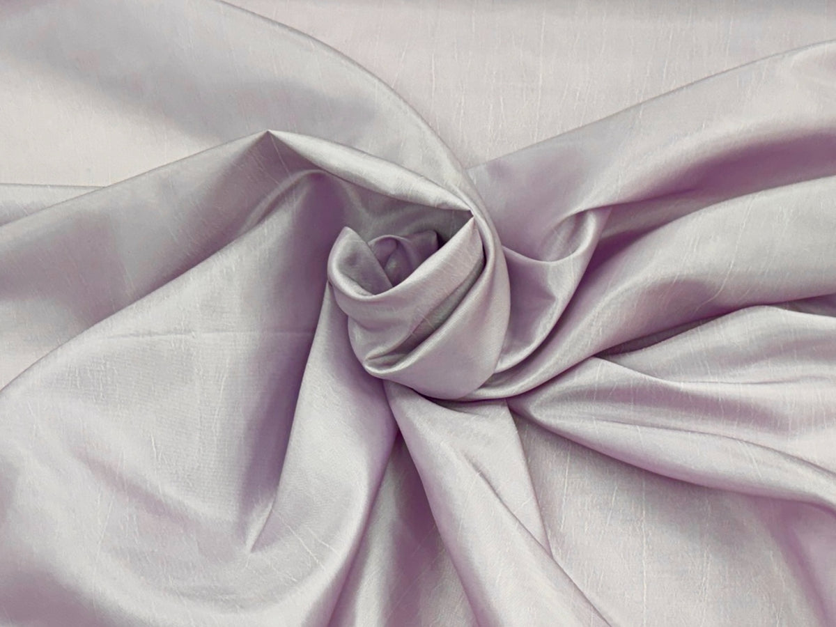 Ice lilac taffeta fabric by Cheapfabrics shown in a close-up image, highlighting its smooth, shiny texture and elegant appearance.