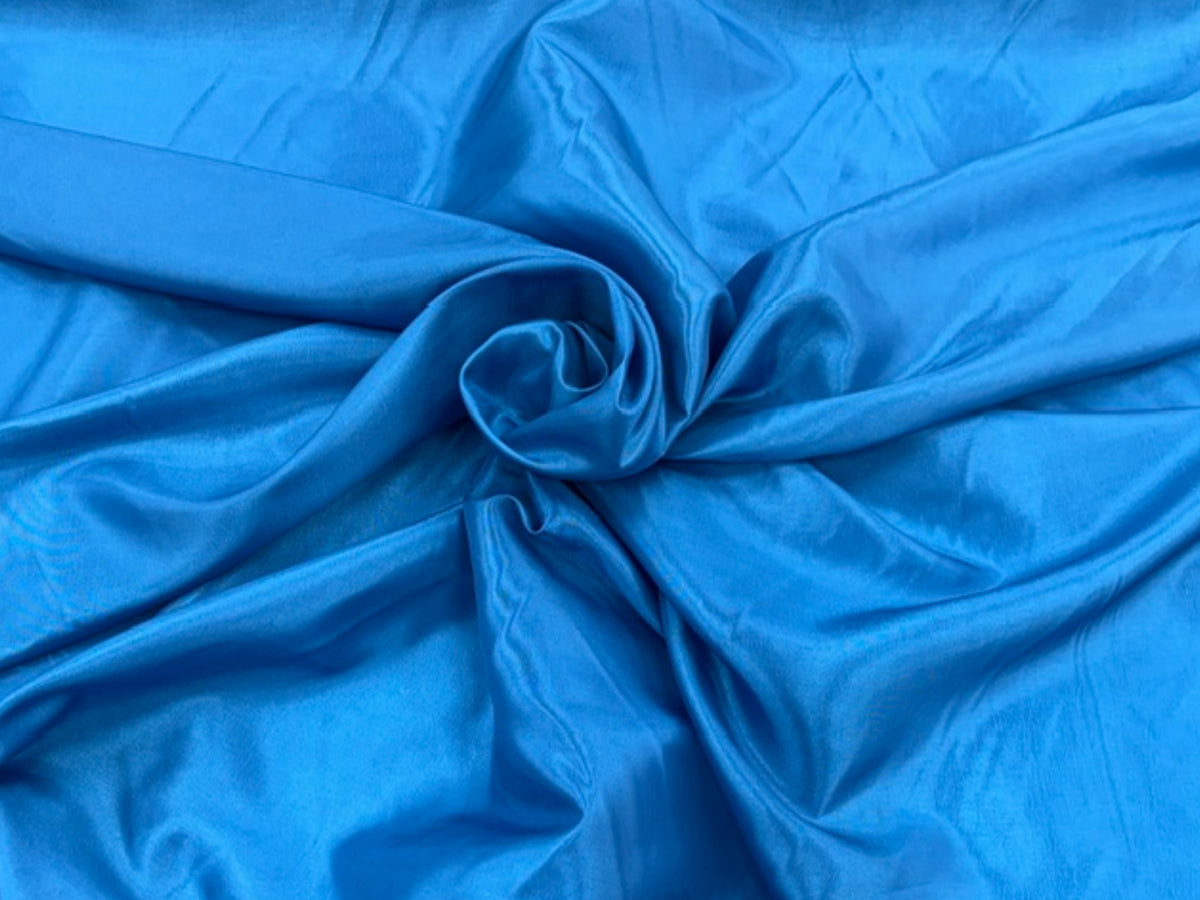 Kingfisher-colored taffeta fabric by Cheapfabrics, showing smooth, shiny taffeta material with a vibrant blue hue.