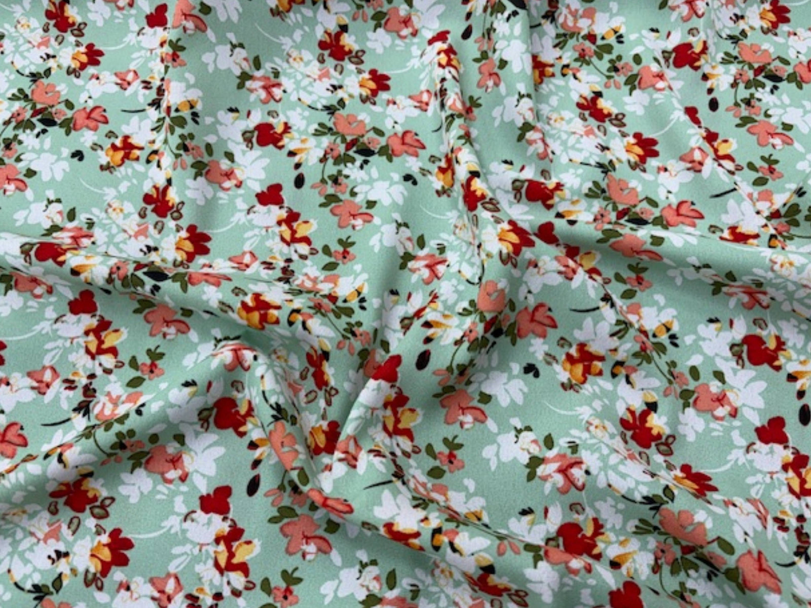 Mint floral printed crepe fabric with a Spanish model, showcasing the soft texture and vibrant floral pattern of Cheap Fabrics.