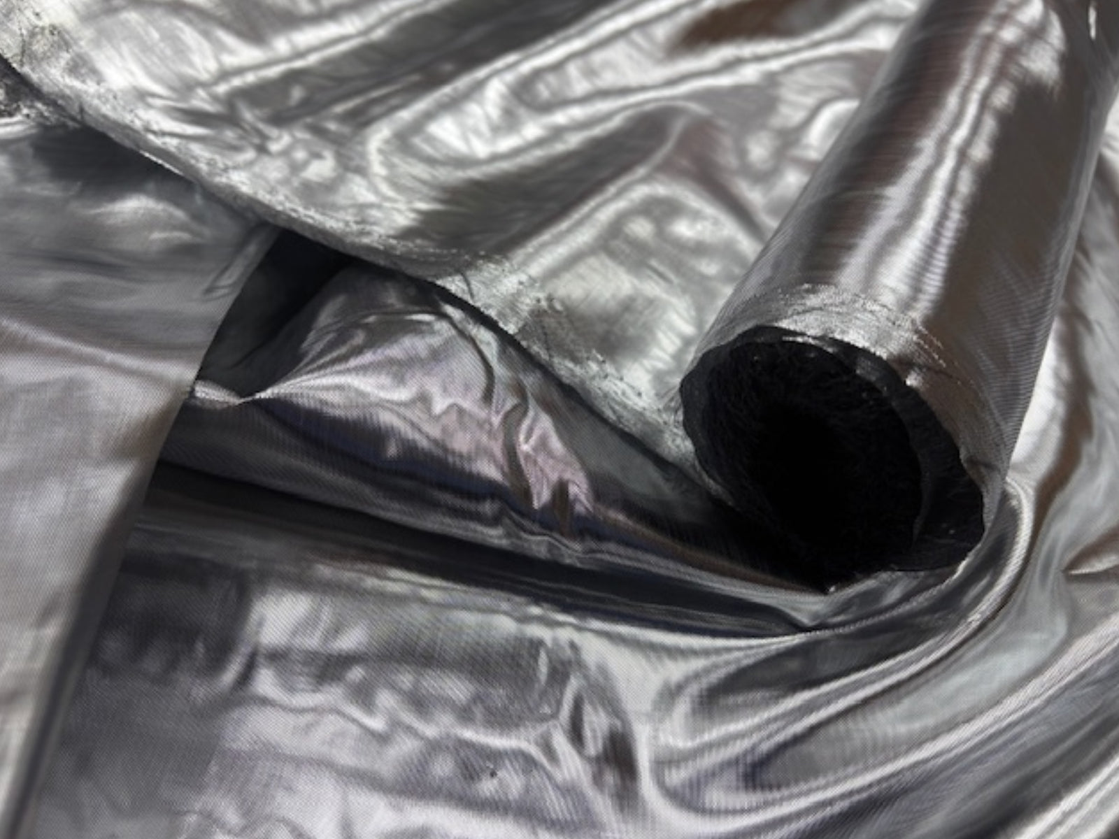 Black and silver plain metallic foil lamé fabric by Cheap Fabrics, showcasing shiny, reflective surface and smooth texture.