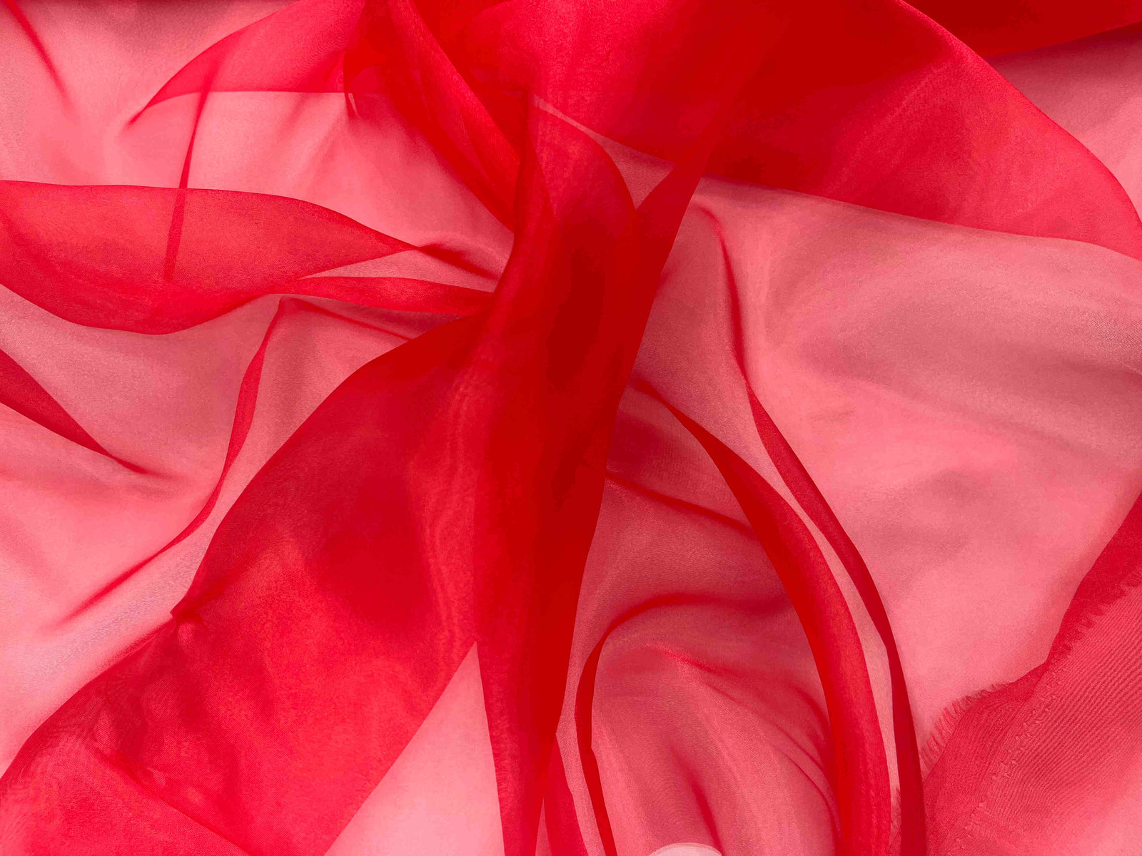 Red shimmer organza fabric from Cheapfabrics, smooth and sheer material suitable for elegant clothing and craft projects.