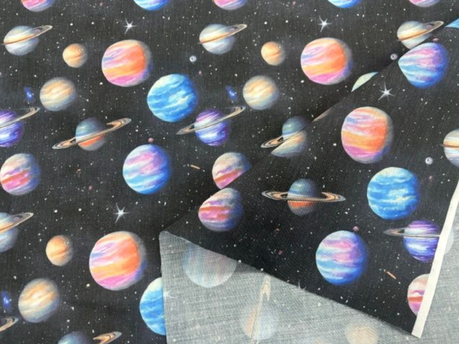 Planets poly/cotton fabric by Cheap Fabrics, featuring colorful planets on a black background