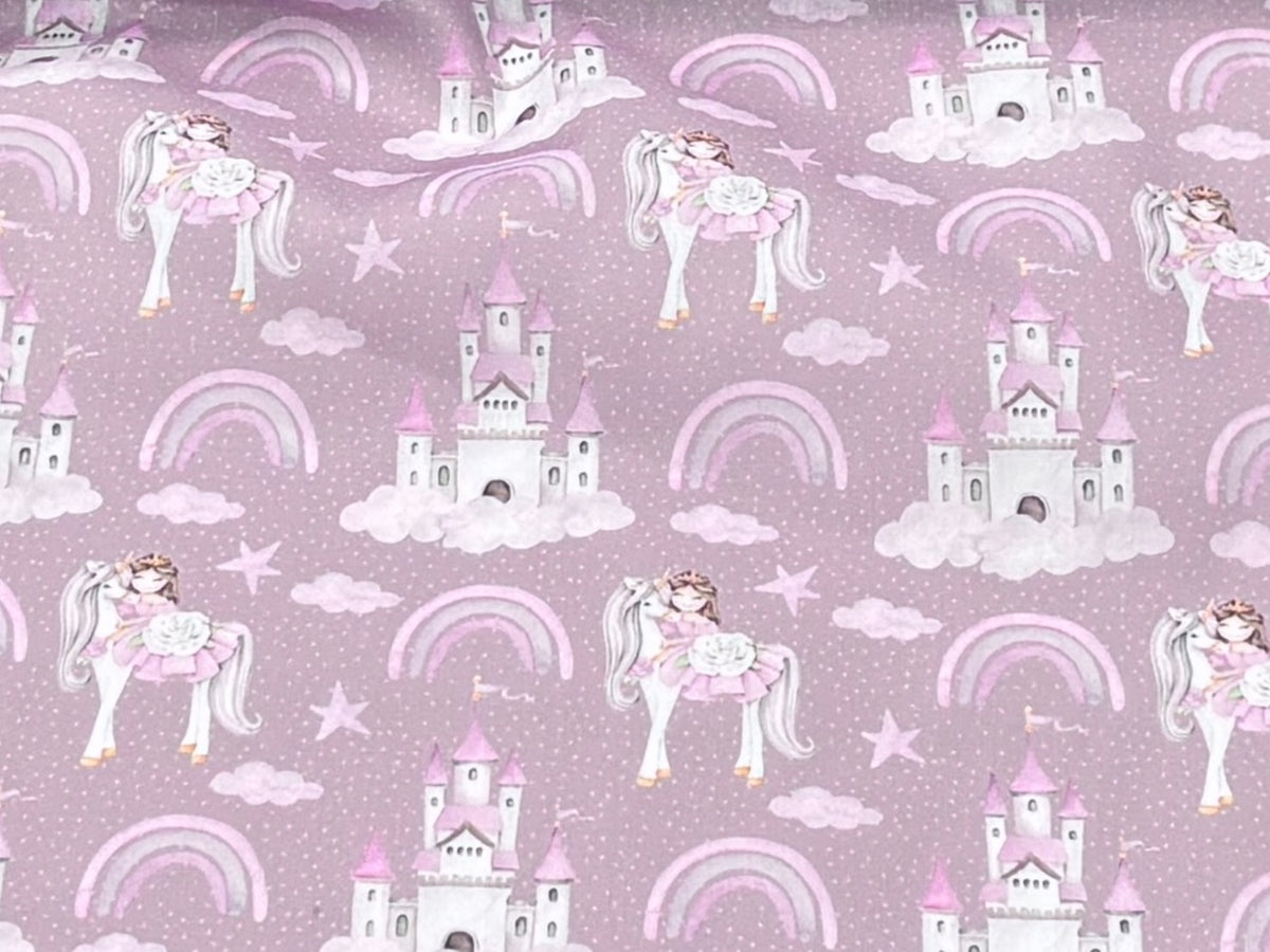 Fairytale princess, unicorn, and castle polycotton fabric with antique pink background, suitable for children's clothing and craft projects.
