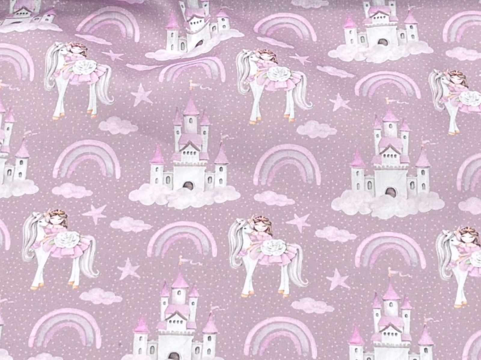 Fairytale princess, unicorn, and castle polycotton fabric with antique pink background, suitable for children's clothing and craft projects.