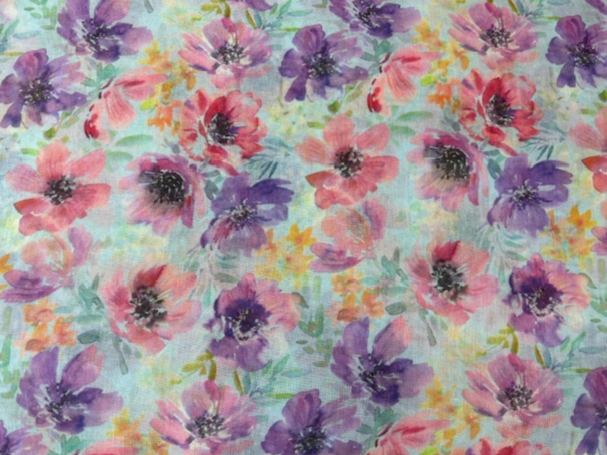 Purple printed voile fabric with watercolor floral design, lightweight and sheer material suitable for clothing and home décor.