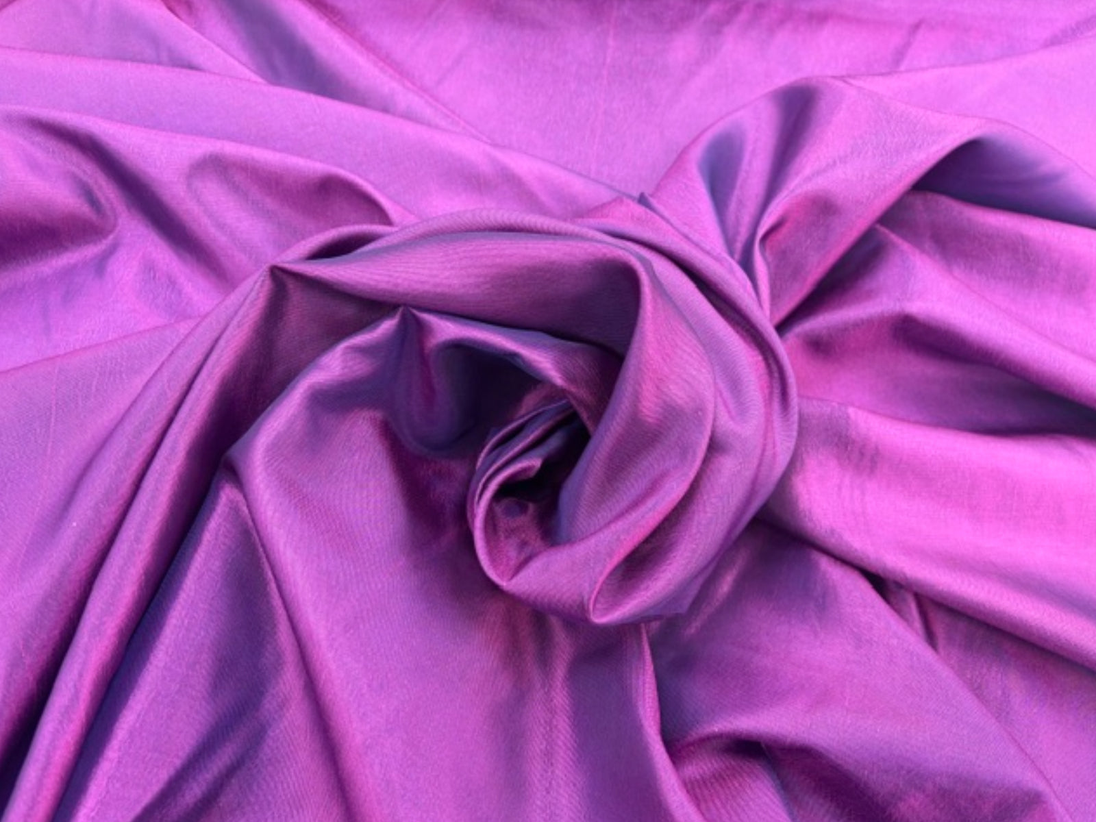 Purple and pink taffeta fabric by Cheapfabrics, shown in a close-up image highlighting its smooth, shiny texture and vibrant color.