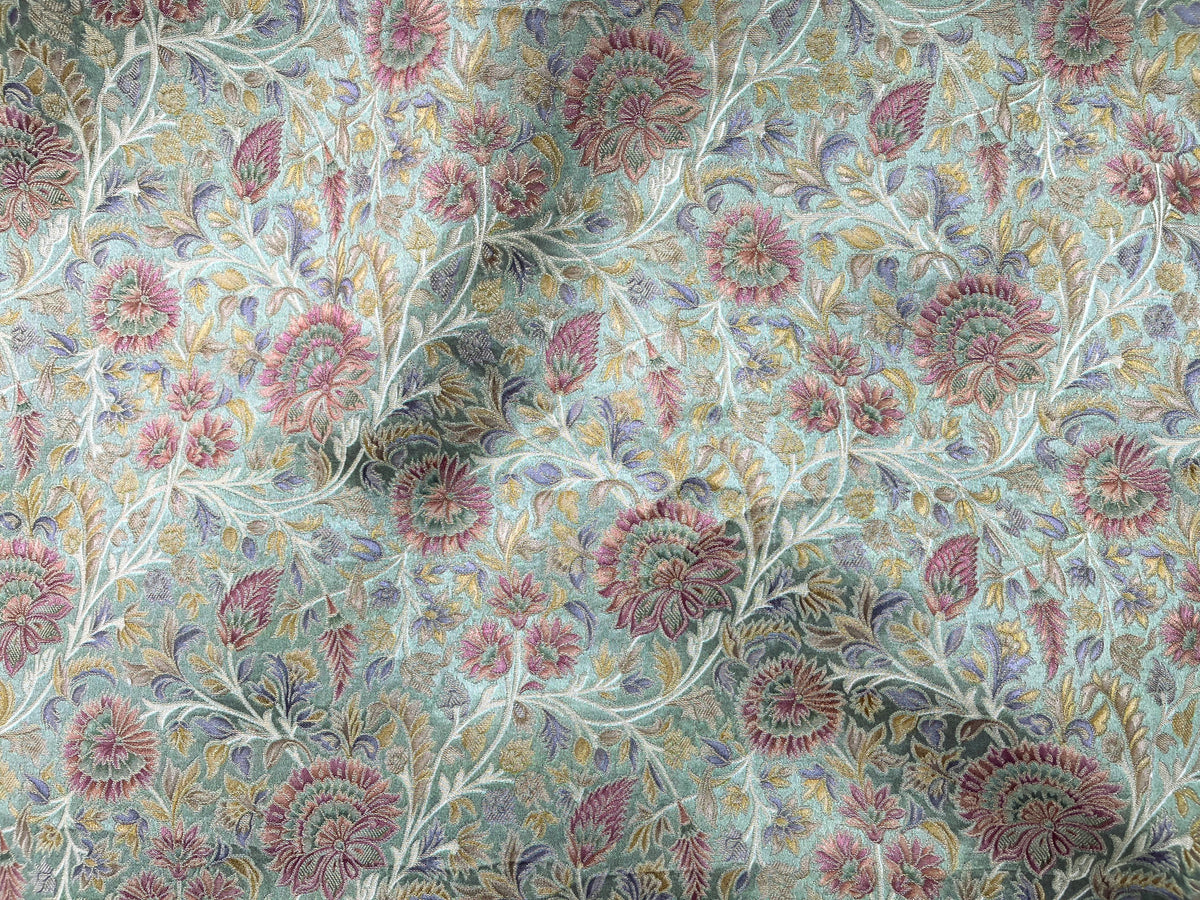 Pastel green royal brocade fabric by Cheapfabrics showing intricate gold floral patterns and luxurious textile texture.