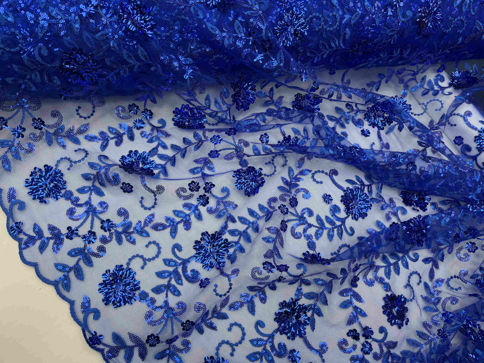 Scalloped lace sequin fabric in royal blue, ideal for elegant bridesmaid dresses and special occasion garments.
