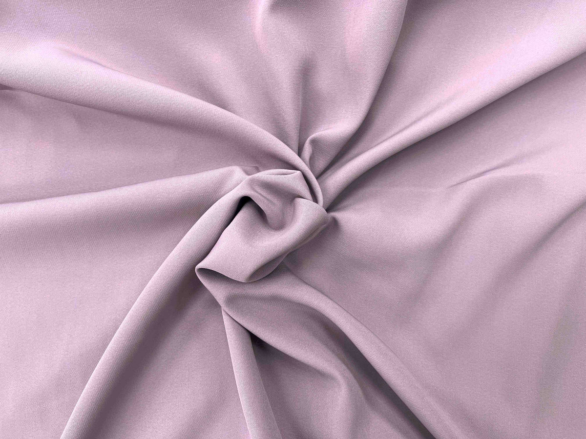 Dusty pink scuba crepe fabric from Cheapfabrics, showcasing its textured surface and lightweight, flowy appearance.