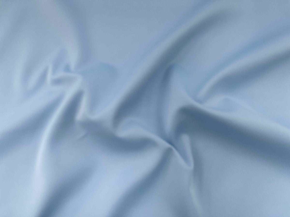 Pale blue plain scuba fabric by Cheapfabrics, showing smooth, stretchy material ideal for fashion and activewear projects.