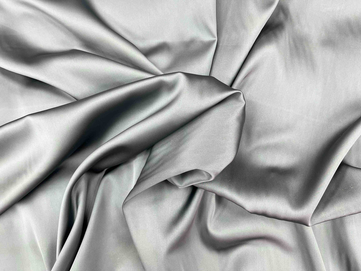 Gray and black satin fabric shot from above, showcasing smooth, shiny satin material from Cheap Fabrics.