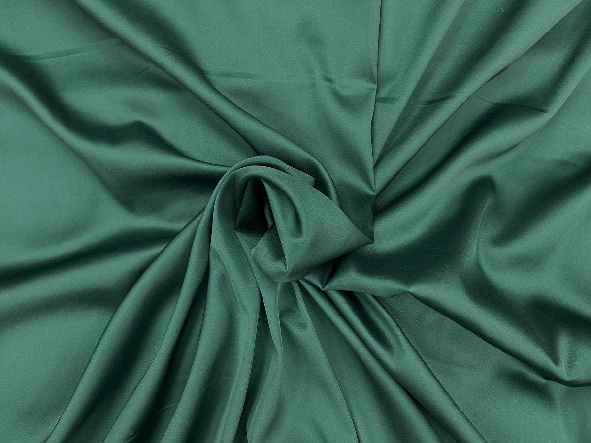 Emerald green plain satin fabric from Cheapfabrics, smooth and sleek satin material perfect for sewing and craft projects.