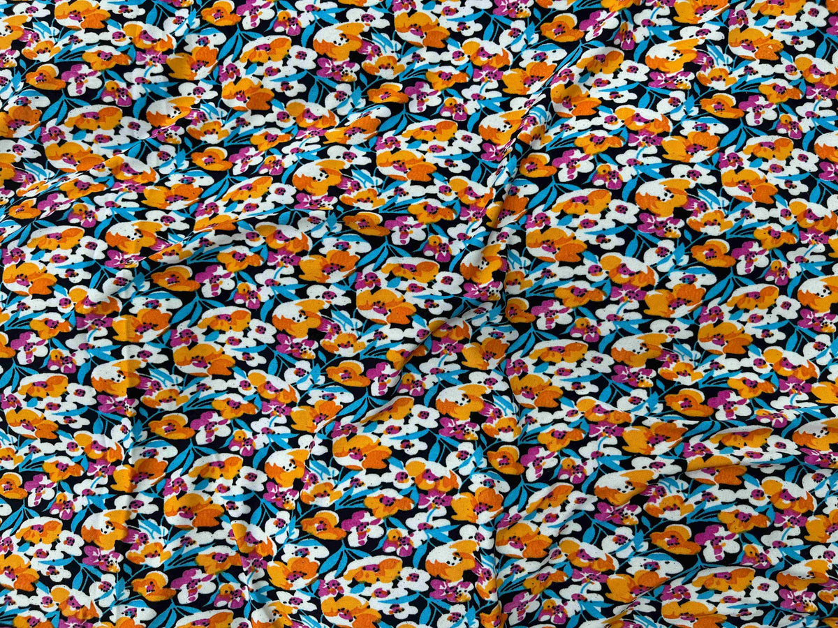 Small floral printed jersey fabric in orange, showcasing soft, lightweight jersey material from Cheapfabrics with vibrant floral design.