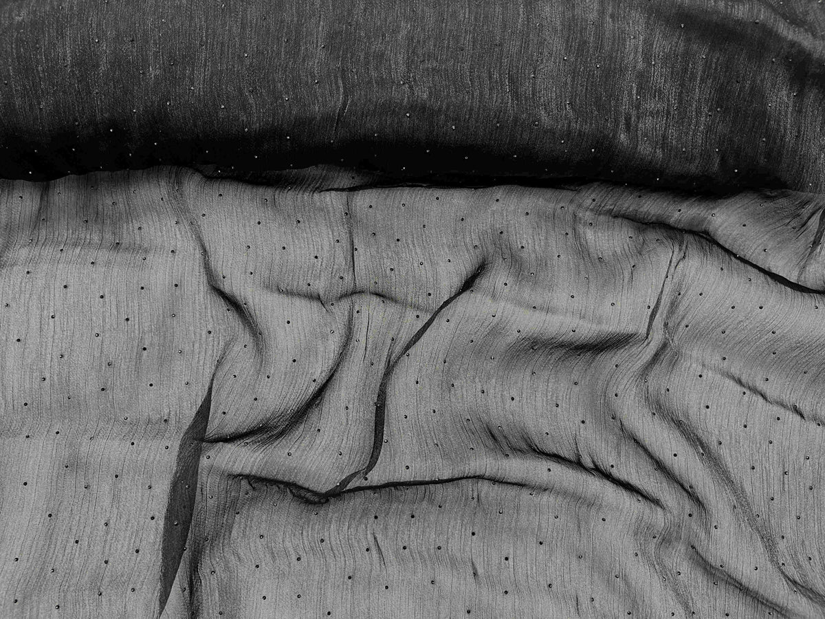 Black Twinkle Stone Organza Fabric by Cheap Fabrics showing shimmering lightweight, sheer material with a subtle sparkle pattern.