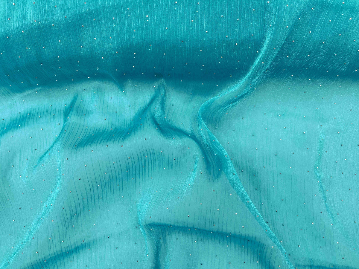 Light green Twinkle Stone Organza Fabric by Cheap Fabrics, showcasing shimmering organza material with a delicate, transparent texture.