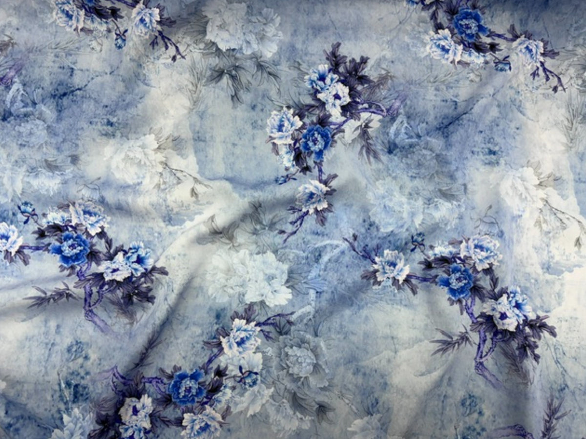 Royal blue floral printed viscose fabric from Cheap Fabrics with a cloudy floral pattern, ideal for clothing and textiles.
