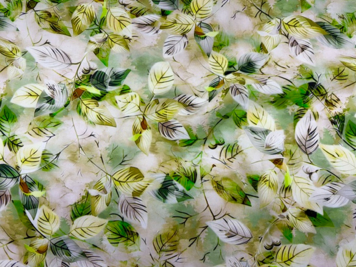 Green Deluxe Printed Viscose Fabric with leaf pattern by Cheap Fabrics, showing smooth, lightweight fabric with vibrant leaf designs.
