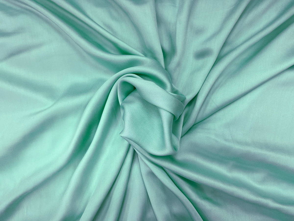 Light green plain viscose satin fabric from Cheapfabrics, showcasing smooth, shiny, and soft viscose material.