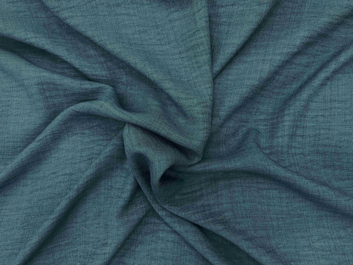 Close-up of washed melange crepe fabric in peacock blue from Cheapfabrics, showing soft, textured, and lightweight material.